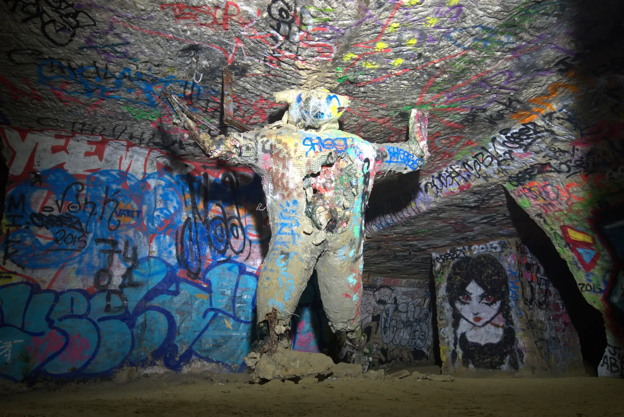 Die Figur steht mitten im Raum, bemalt wie alles hier.